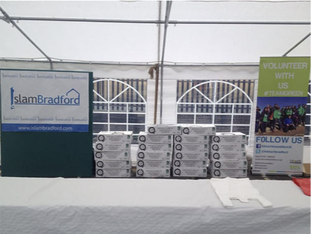 An empty table inside a gazebo with Islam Bradford branding behind it.